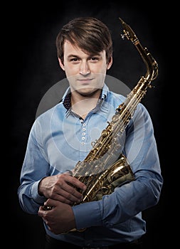 Attractive saxophonist on a dark background.