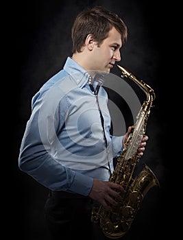 Attractive saxophonist on a dark background.