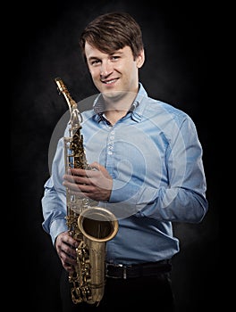 Attractive saxophonist on a dark background.