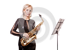 Attractive saxophonist woman playing at her musical instrument