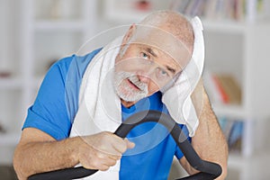 attractive senior man at health club exercising on stepper