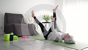 Attractive Senior Woman At Home Practicing Yoga Training And Stretching