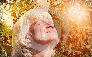 Attractive senior woman taking a deep breath while walking at the evening