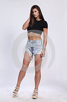 Attractive, sexy muscular brunette caucasian girl posing in studio on isolated background. Style, trends, fashion concept.