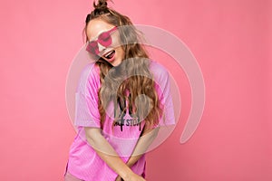 Attractive sexy shy young blonde woman wearing everyday stylish clothes and modern sunglasses  on colorful