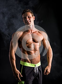 Attractive shirtless muscular man smiling at camera