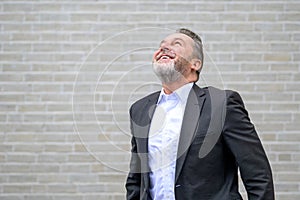 Attractive sixty year old gray man looking up with a big smile