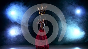 Attractive slim belly dancer go on dancing with candles, her head, black, smoke