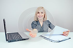 Attractive smart blonde multitasking female person business lady in stylish business suit extends a hand for a handshake