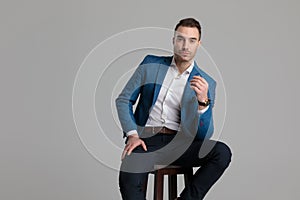 Attractive smartcasual guy holding elbow on knee