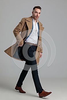 Attractive smartcasual man adjusting long coat