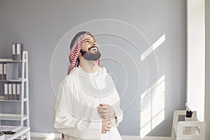 Attractive smiling arab man laughing rejoices standing in a modern office
