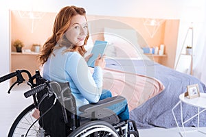 Attractive smiling disabled woman holding a book