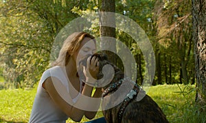 Attractive smiling woman kissing her nice dog