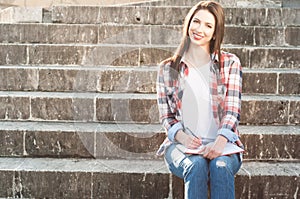 Attractive smiling woman writing into her notebook in the park