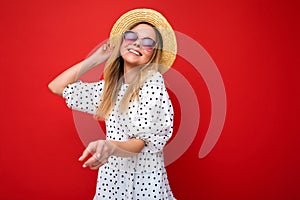 Attractive smiling young blonde woman wearing everyday stylish clothes and modern sunglasses isolated on colorful