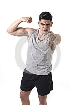 Attractive sport man with big and strong athletic body in singlet pointing to the camera showing biceps