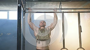 Attractive sport man doing pull ups in gym.