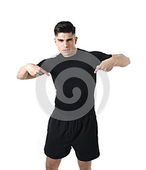 Attractive sport man pointing on his black t-shirt with copy space for adding gym fitness health club logo
