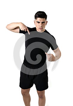 Attractive sport man pointing on his black t-shirt with copy space for adding gym fitness health club logo