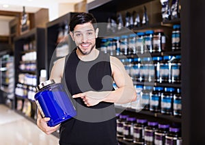 Attractive sport man seller demostration different sport nutrition products photo