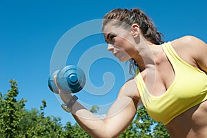 Attractive sport woman with dumbbells on the playground