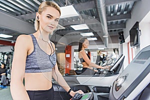 attractive sportive woman running on treadmill at gym