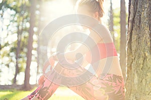 Attractive sportive woman wearing smart watch taking a break after workout session. Lifestyle image with strong lens flare