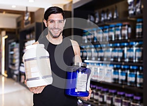 Attractive sportman seller demostration different sport nutrition photo