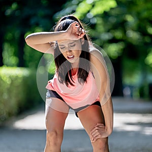 Attractive sports woman runner taking a break feeling tired after running