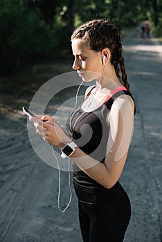 attractive sportswoman with earphones smart watch