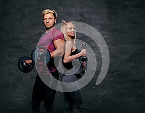 Attractive sporty couple over grey background.