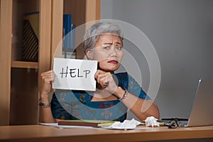 Attractive stressed and overworked Asian woman working at office laptop computer desk in stress feeling frustrated and helpless