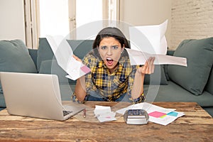 Attractive stressed woman managing finances, reviewing bank accounts, paying bills using laptop