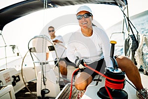 Attractive strong woman sailing with her boat