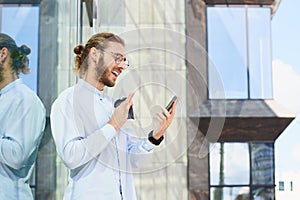 Attractive strong young man in office clothes speaks facetime