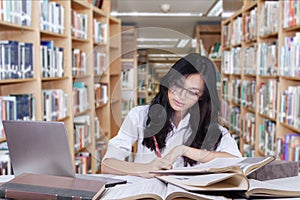 Attractive student with long hair studying in library