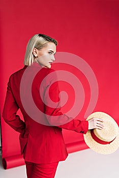 attractive stylish girl in red jacket with straw hat