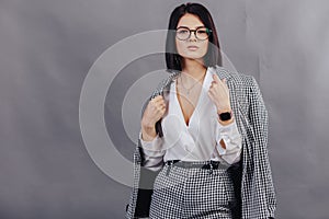 Attractive stylish young girl in business clothes posing on dark background. concept of stylish clothes and sophistication