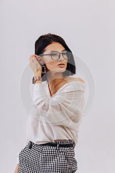 Attractive stylish young girl in business clothes posing on light background in studio. concept of stylish clothes and
