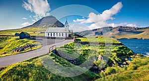 Attractive summer view of Vidareidi Kirkja. Colorful outdoor scene of Vidareidi village, Vidoy island. Bright morning view of Faro