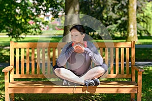 Attractive supple woman sitting on a park bench photo