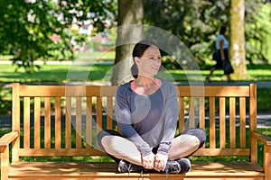 Attractive supple woman sitting on a park bench photo