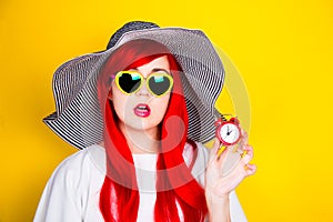 Attractive surprised red-haired young woman in sunglasses and ha
