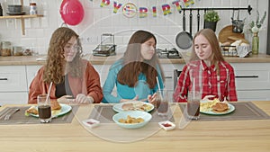 Attractive teen female friends overeat of tasty festive meal at birthday party