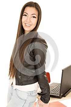 Attractive teen girl leaning on desk by computer