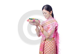 Attractive Thai woman dressed in traditional Thai clothes holds a flower basket