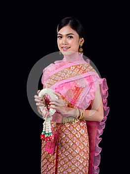 Attractive Thai woman dressed in traditional Thai clothes holds a flower garland made from natural materials