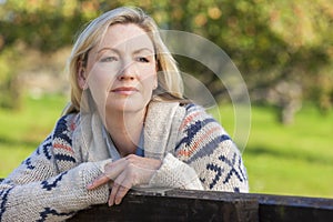 Attractive Thoughtful Middle Aged Woman Resting on Fence