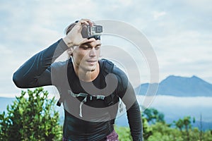 Attractive Traveler vith GoPrO camera on his hand against the Ba